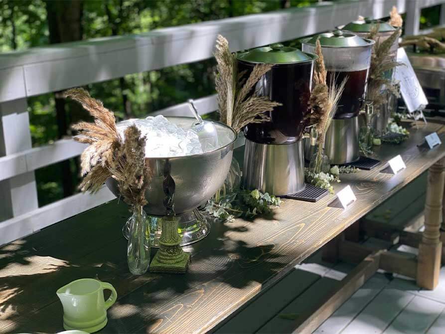 A wooden bench with several containers of drinks on it.