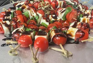 A platter of food that includes tomatoes and cheese.