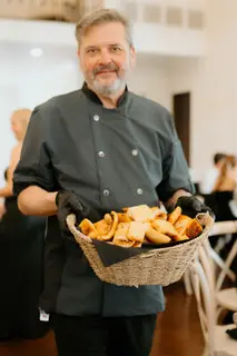 A man holding a basket of food in his hands.