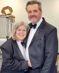 A man and woman in suits posing for a picture.